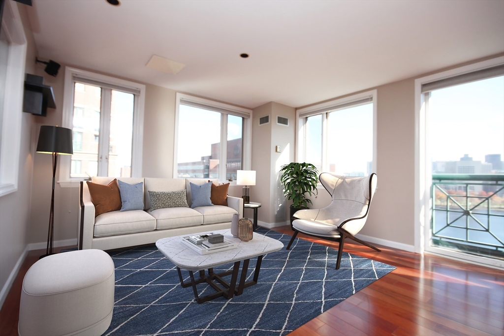 a living room with furniture a wooden floor and a large window