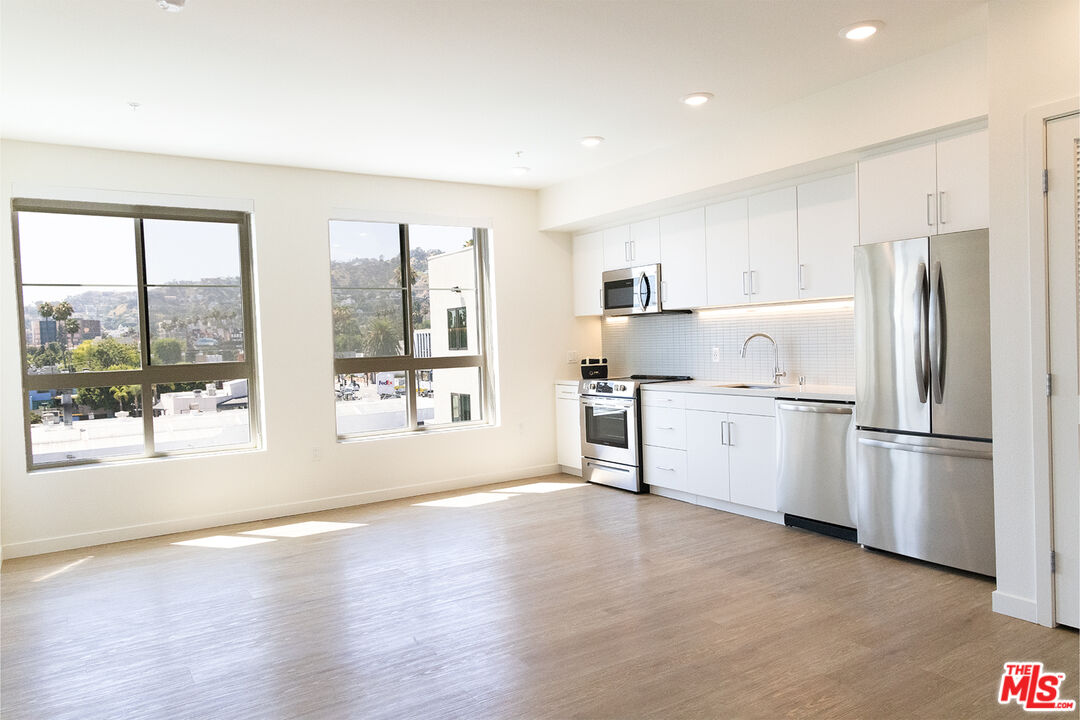 a kitchen with stainless steel appliances a refrigerator sink and cabinets