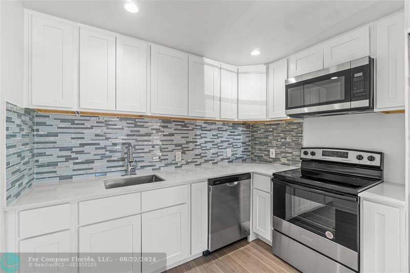 a kitchen with stainless steel appliances white cabinets and a stove a oven