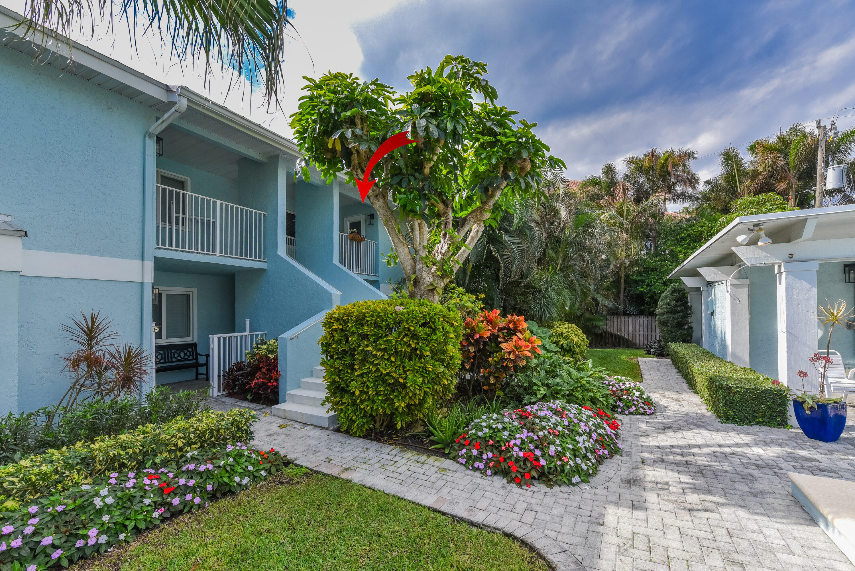 a front view of a house with a yard and flower garden