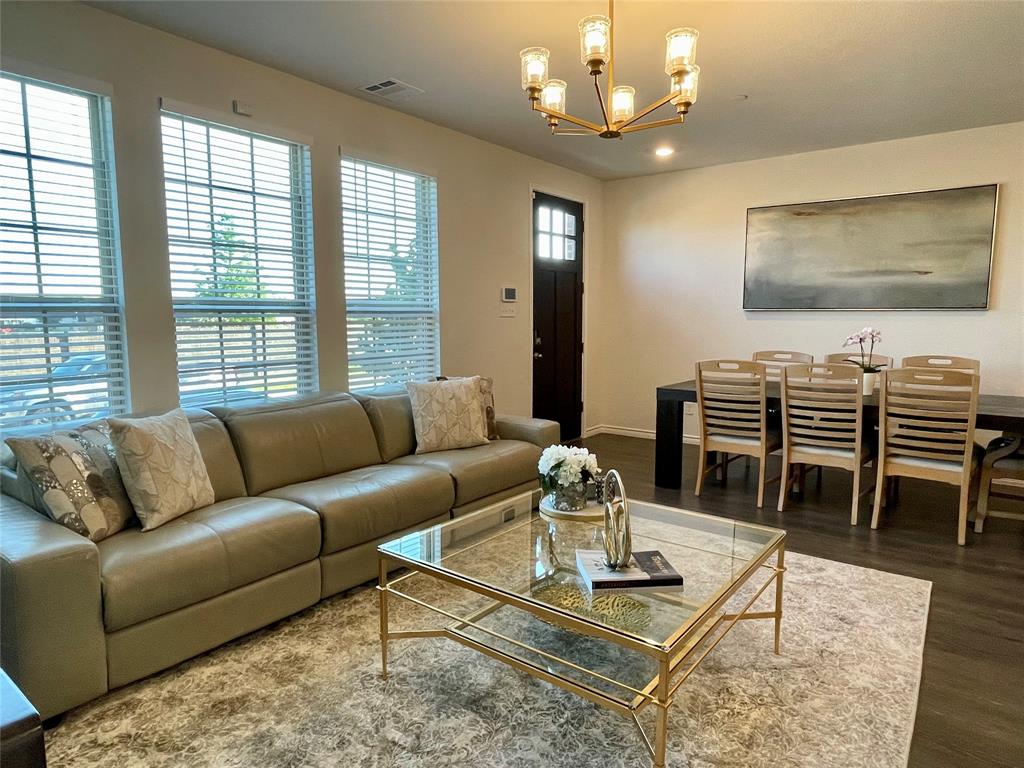 a living room with furniture a chandelier and a flat screen tv