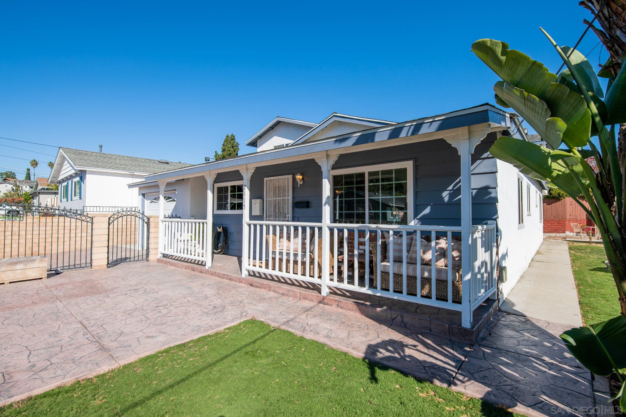 a view of a house with a small yard and wooden fence