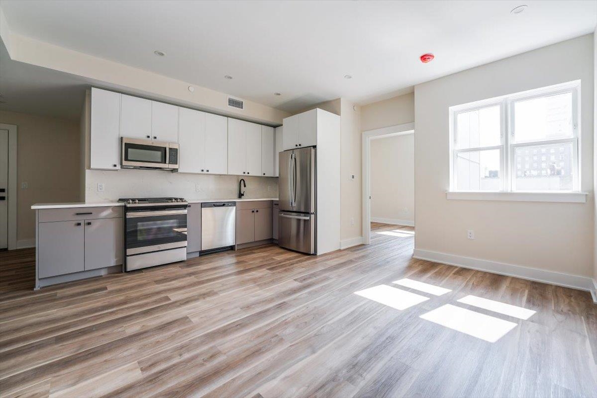 a kitchen with stainless steel appliances granite countertop a refrigerator and a stove top oven