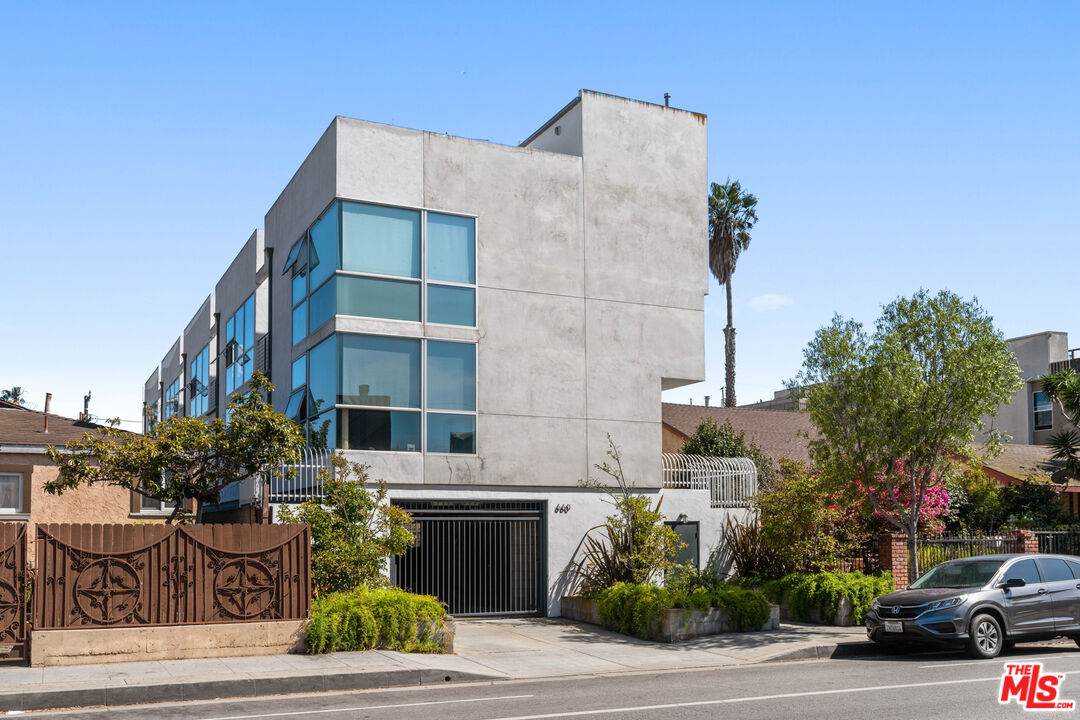 a multi story building with potted plants in front of it