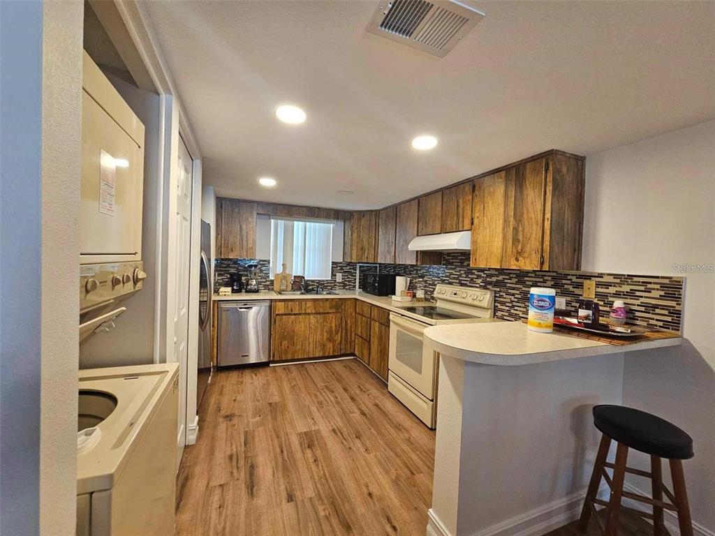 a kitchen with a sink appliances cabinets and furniture