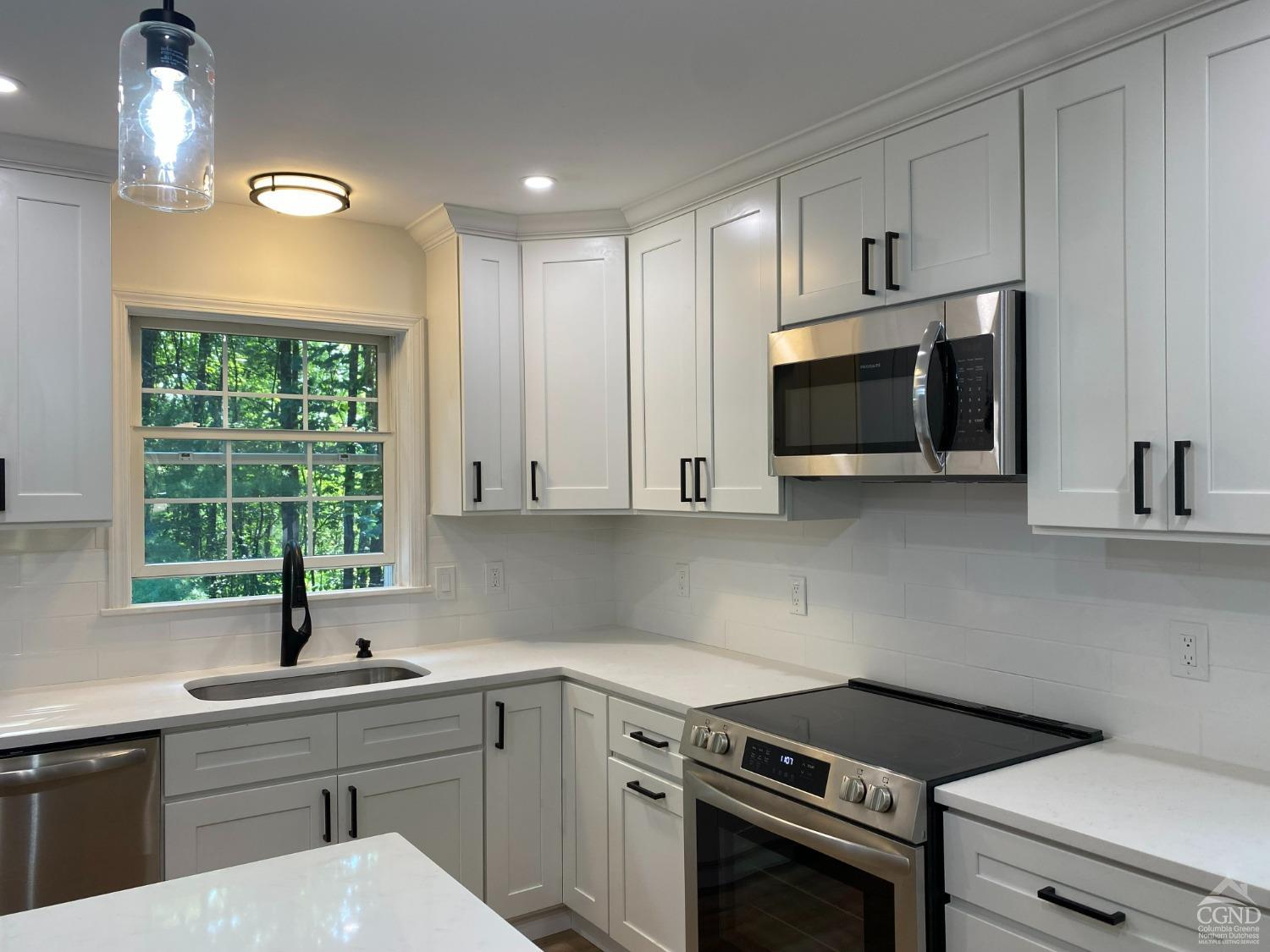 a kitchen with a sink stove and microwave