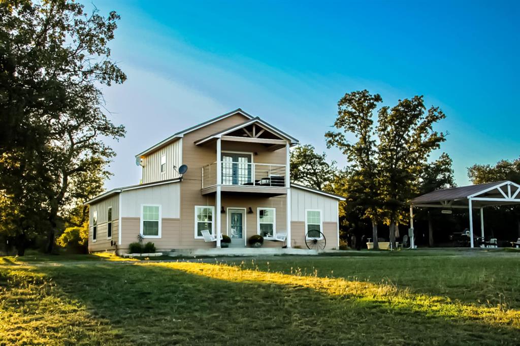 a front view of a house with a garden and trees