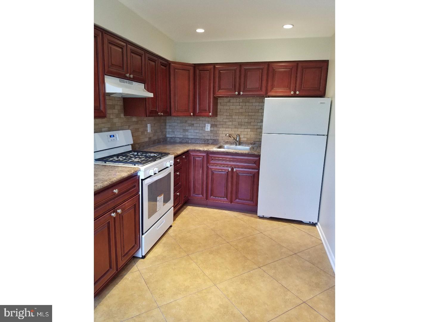 a kitchen with stainless steel appliances granite countertop a stove a sink and a refrigerator with cabinets