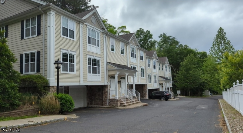 a large building with a small yard and large trees