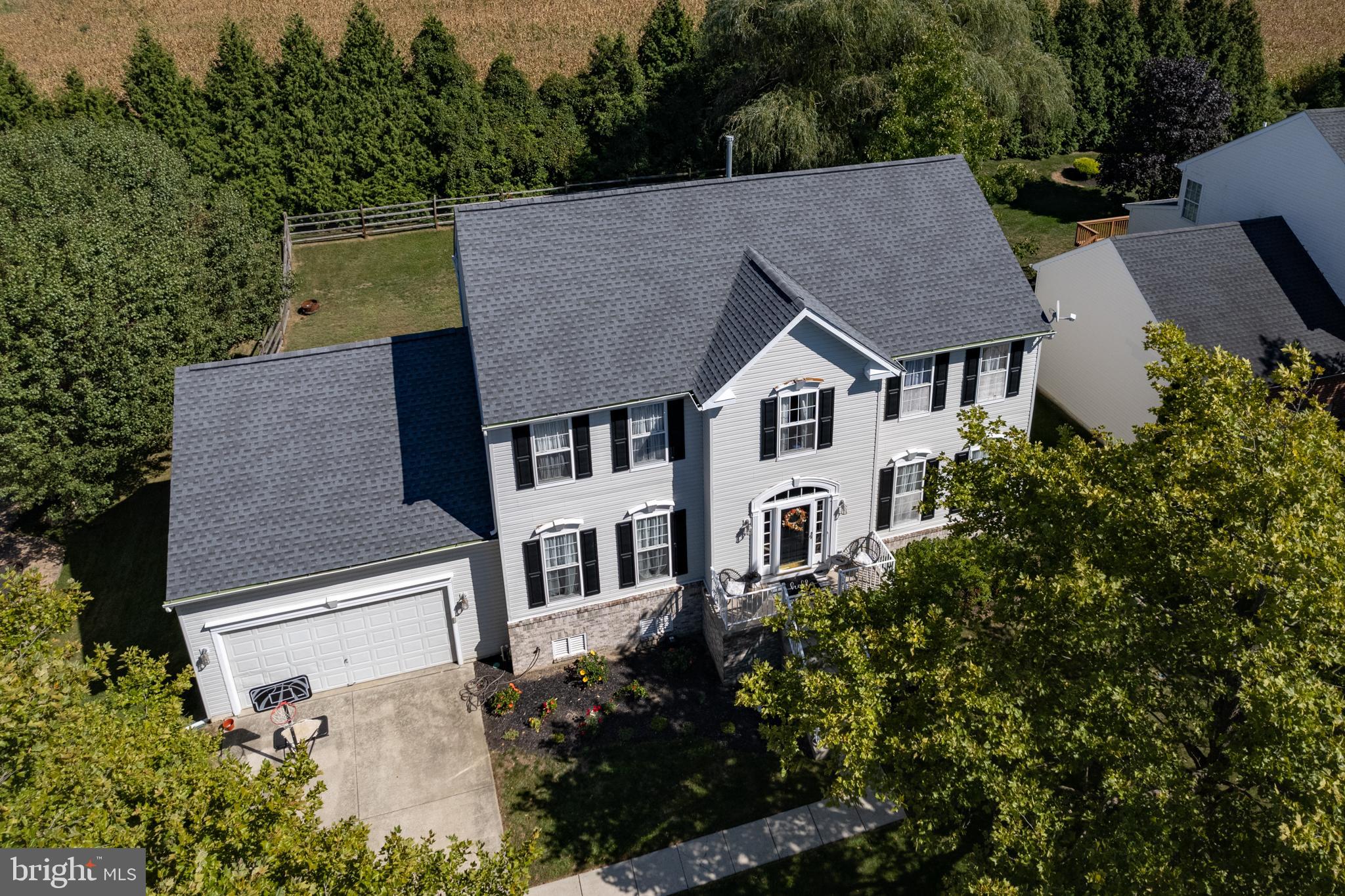 an aerial view of a house with a yard and trees all around