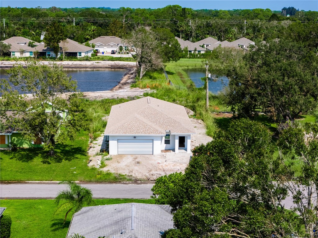 a aerial view of a house with a yard and lake view