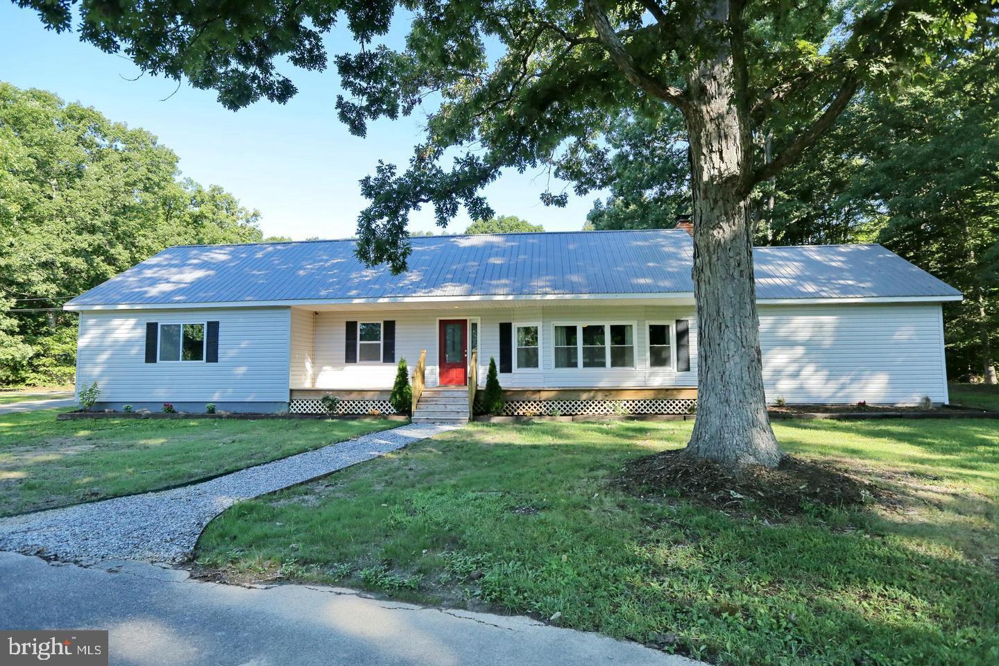 a front view of house with yard and trees in the background