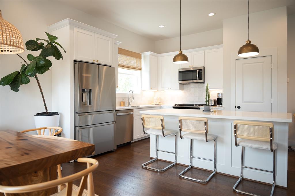 a kitchen with kitchen island a counter top space a sink stainless steel appliances and cabinets