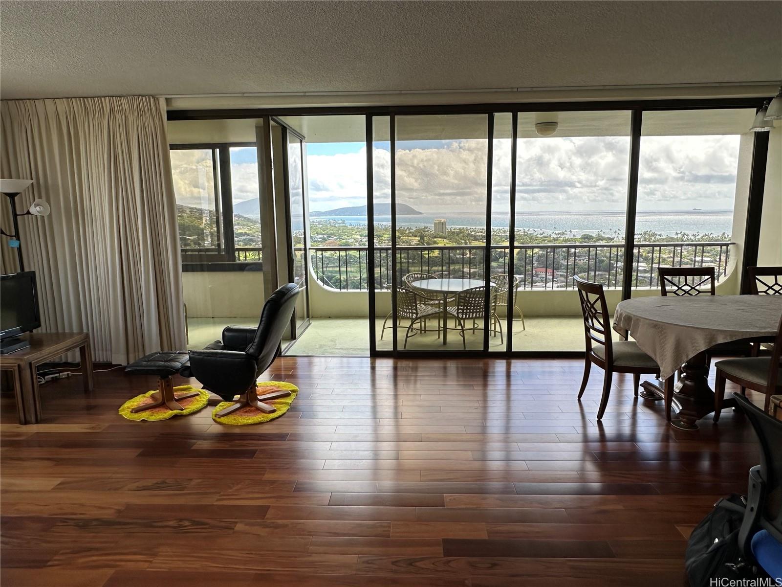 a view of a workspace with furniture and floor to ceiling window