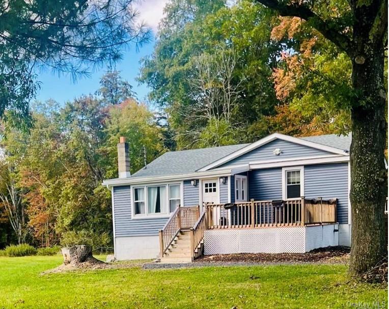 View of front of property with a front yard and a deck