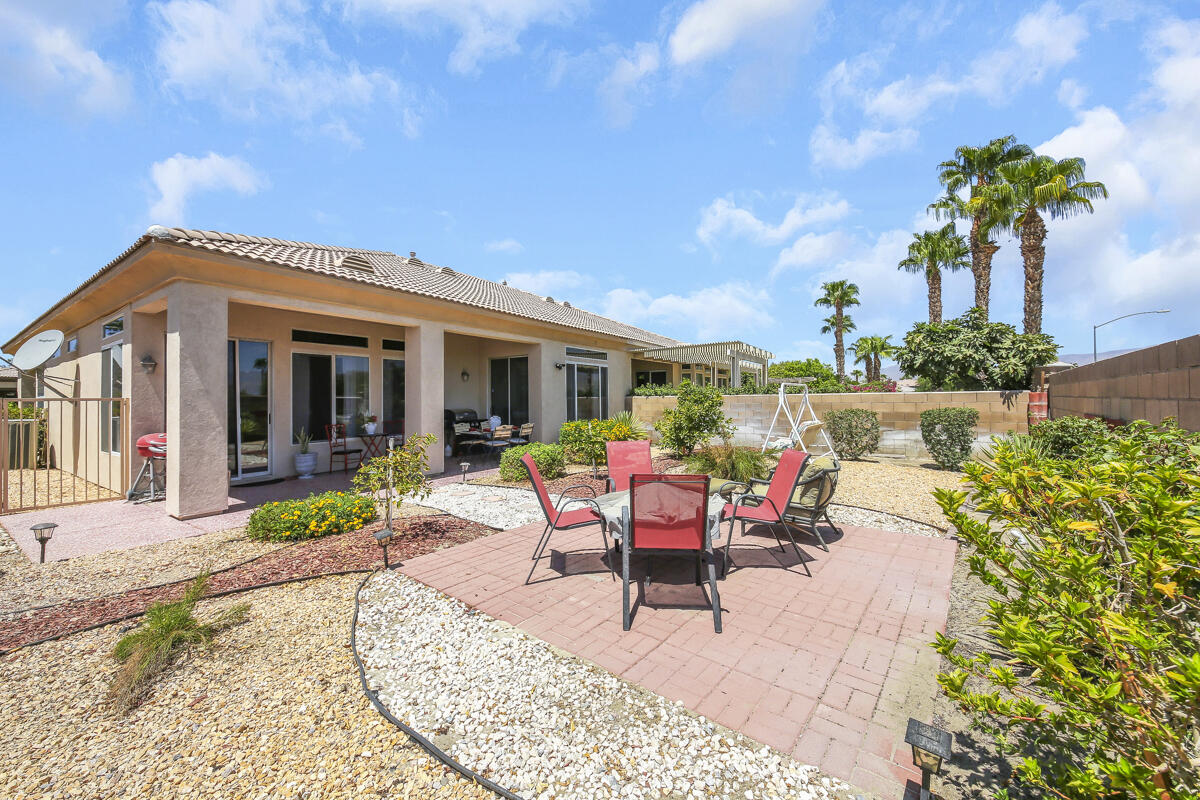 a view of a house with backyard sitting area and garden