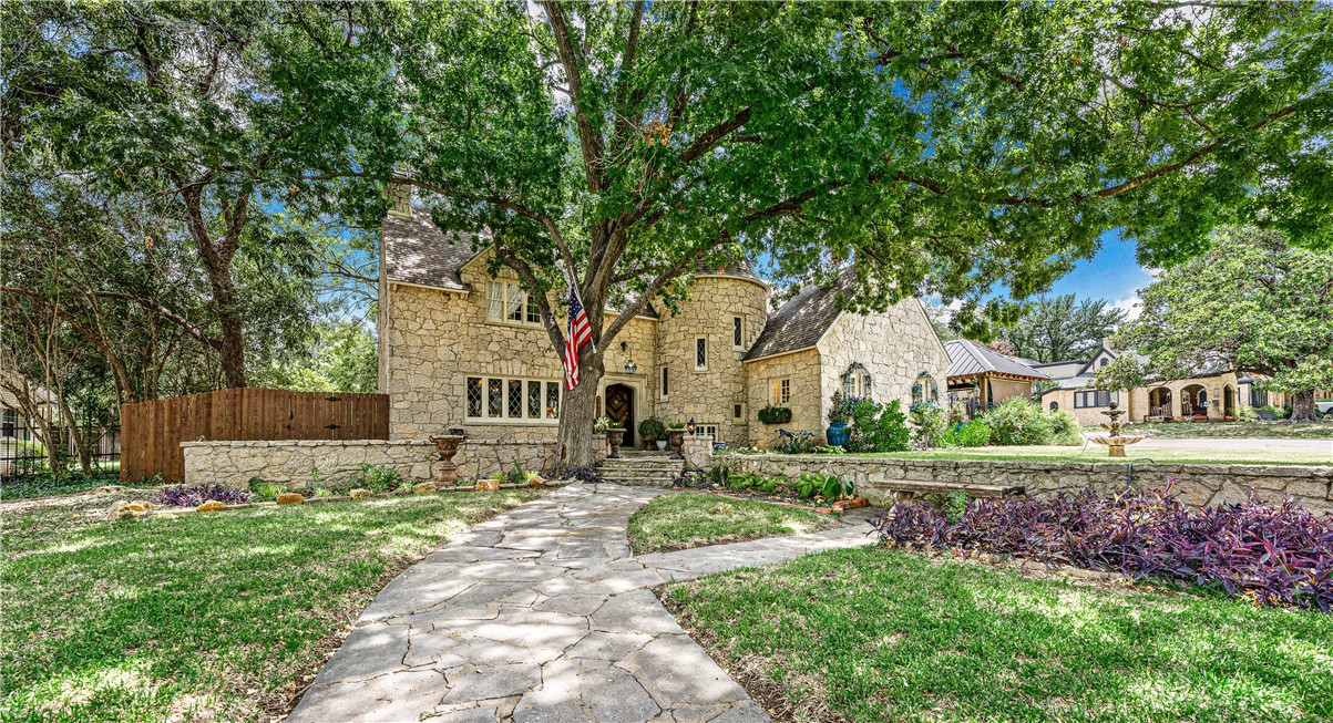 a front view of a house with a yard and an trees