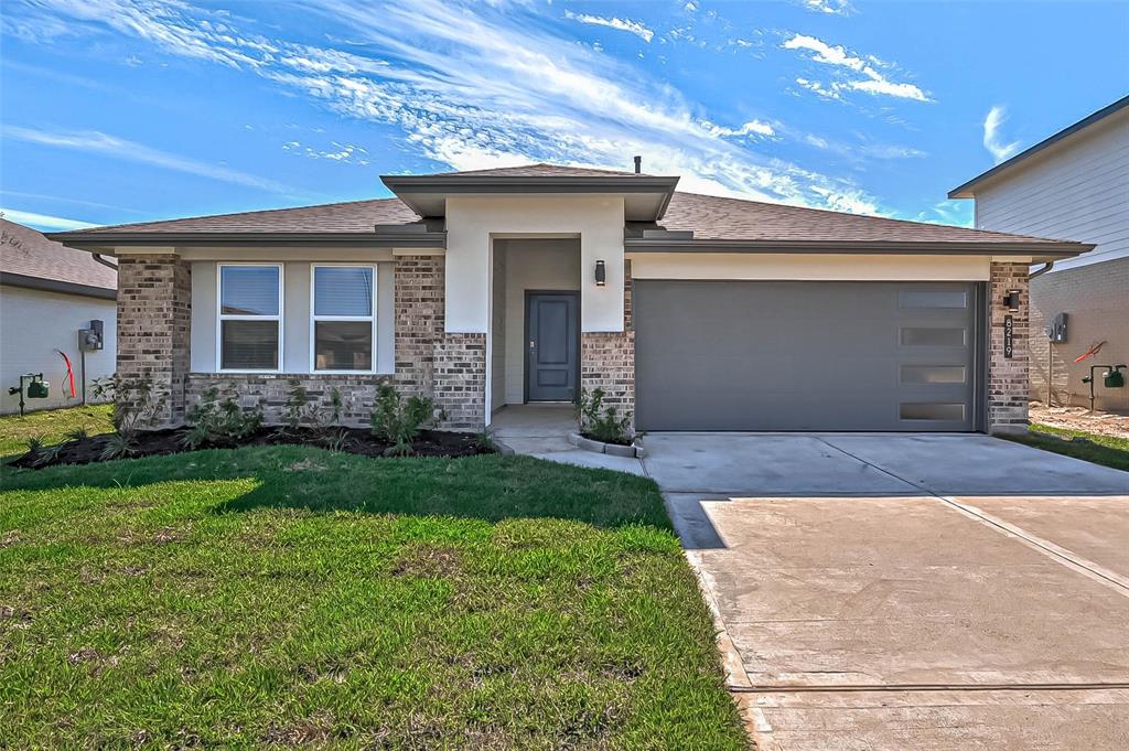 a front view of a house with a yard and garage