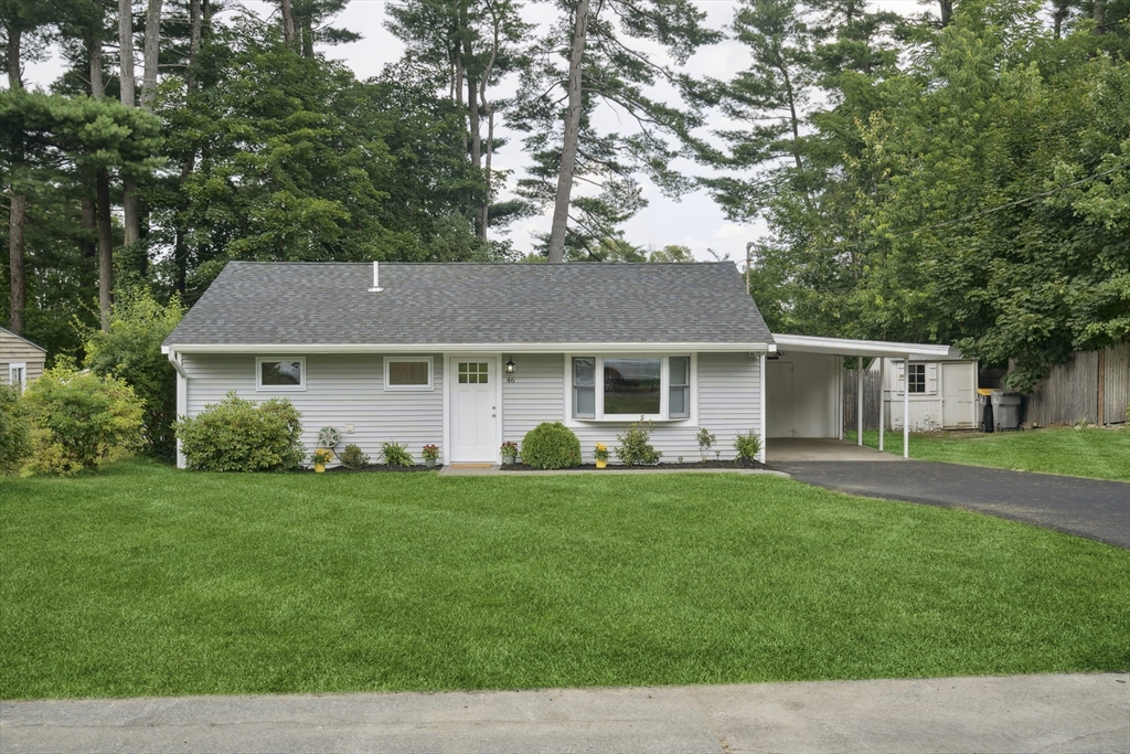 a front view of a house with a garden and trees