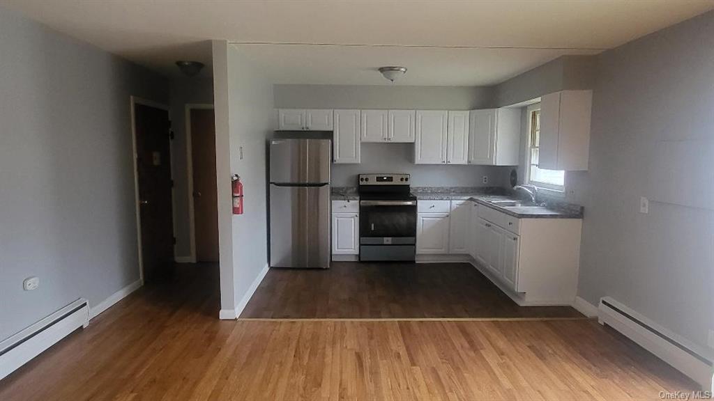 a kitchen with a sink a refrigerator and cabinets