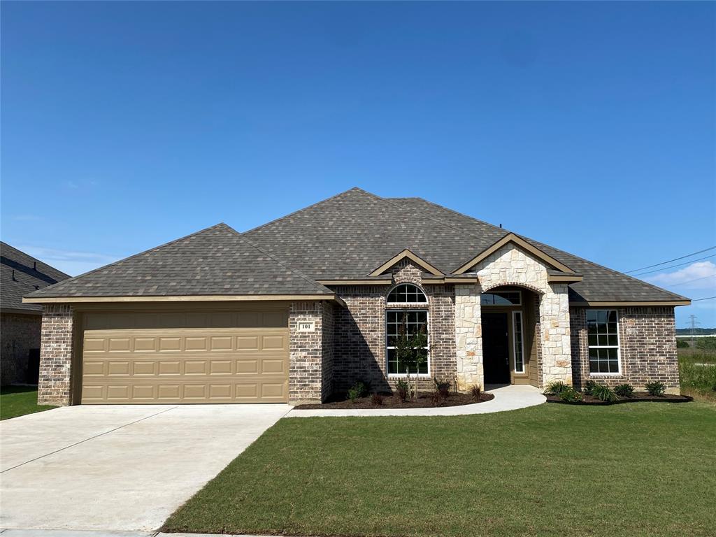 a front view of a house with a garden and yard