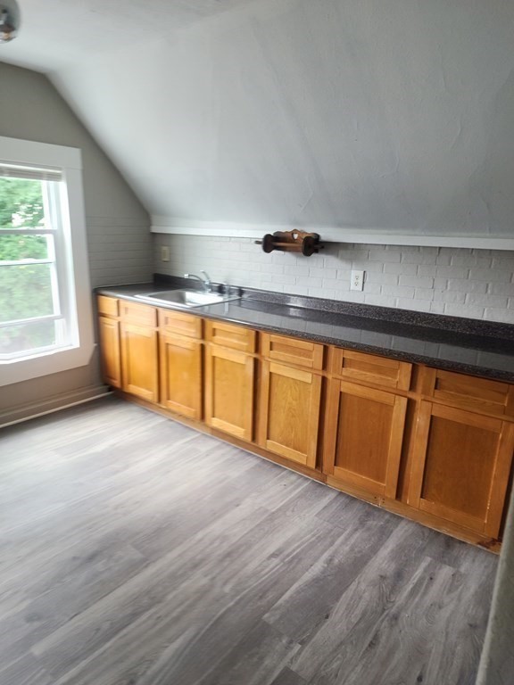 a view of a kitchen with wooden floor and a sink