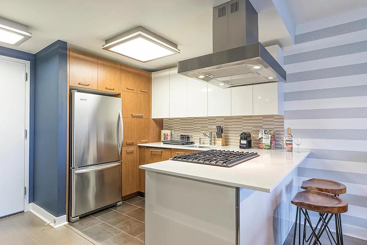 a kitchen with a refrigerator and a stove top oven