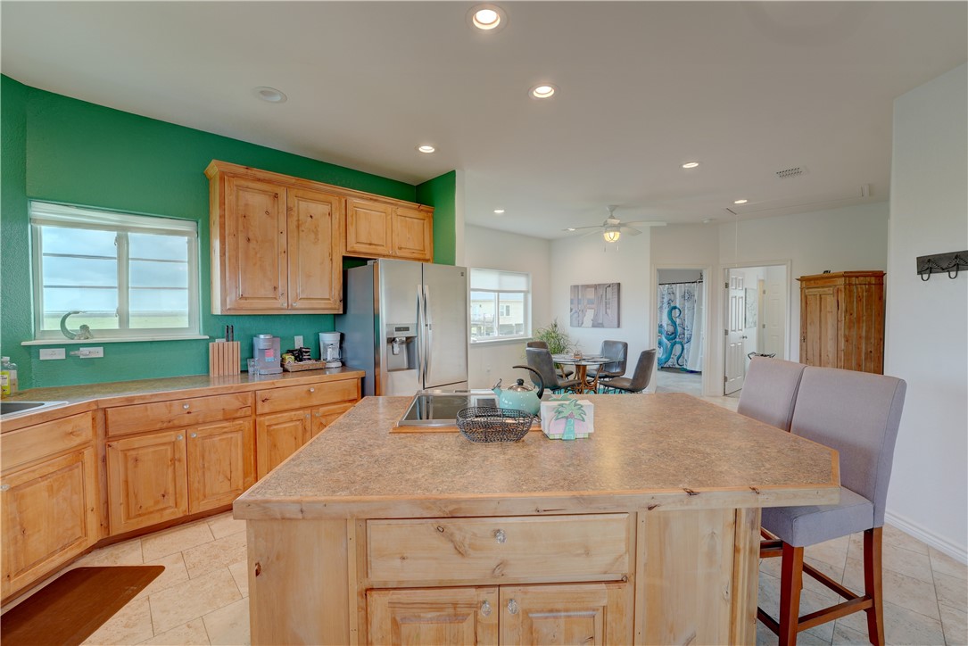 a kitchen with stainless steel appliances granite countertop a sink a stove a dining table and chairs