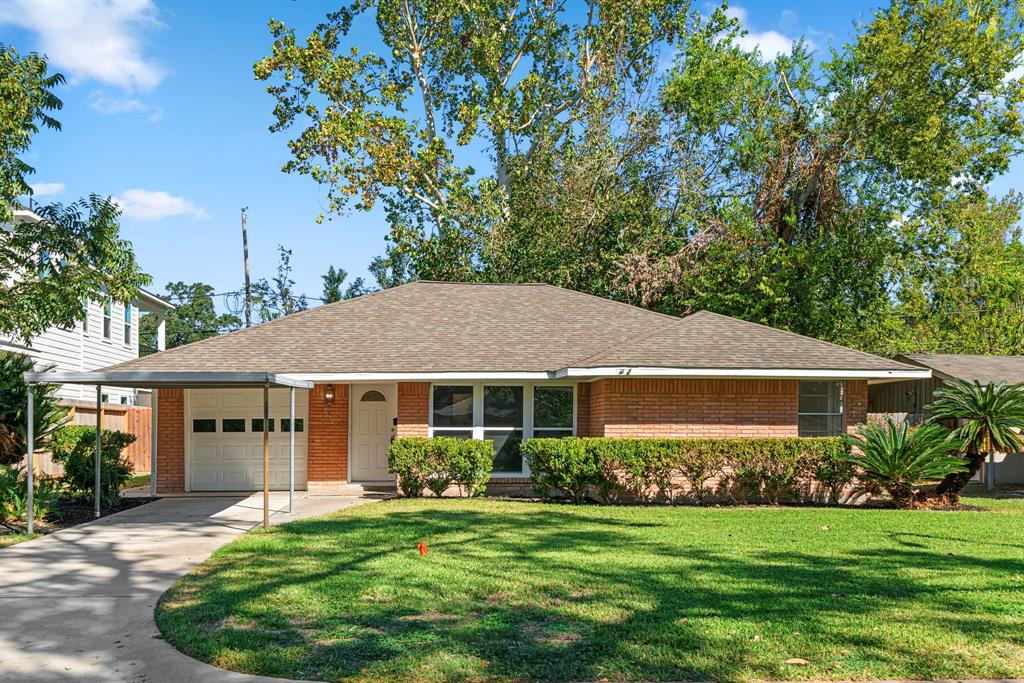 a front view of a house with a garden and trees