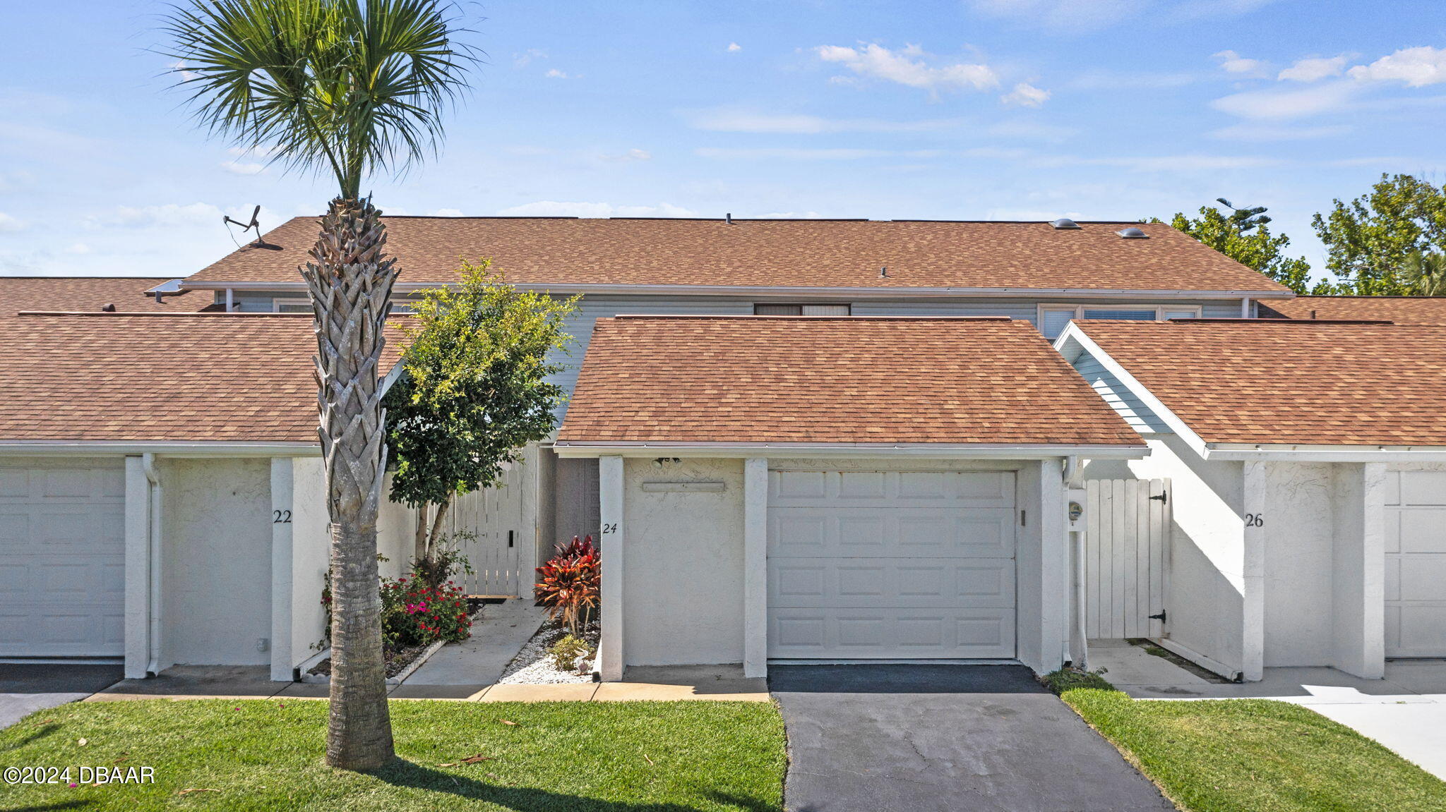 front view of house with a yard and potted plants