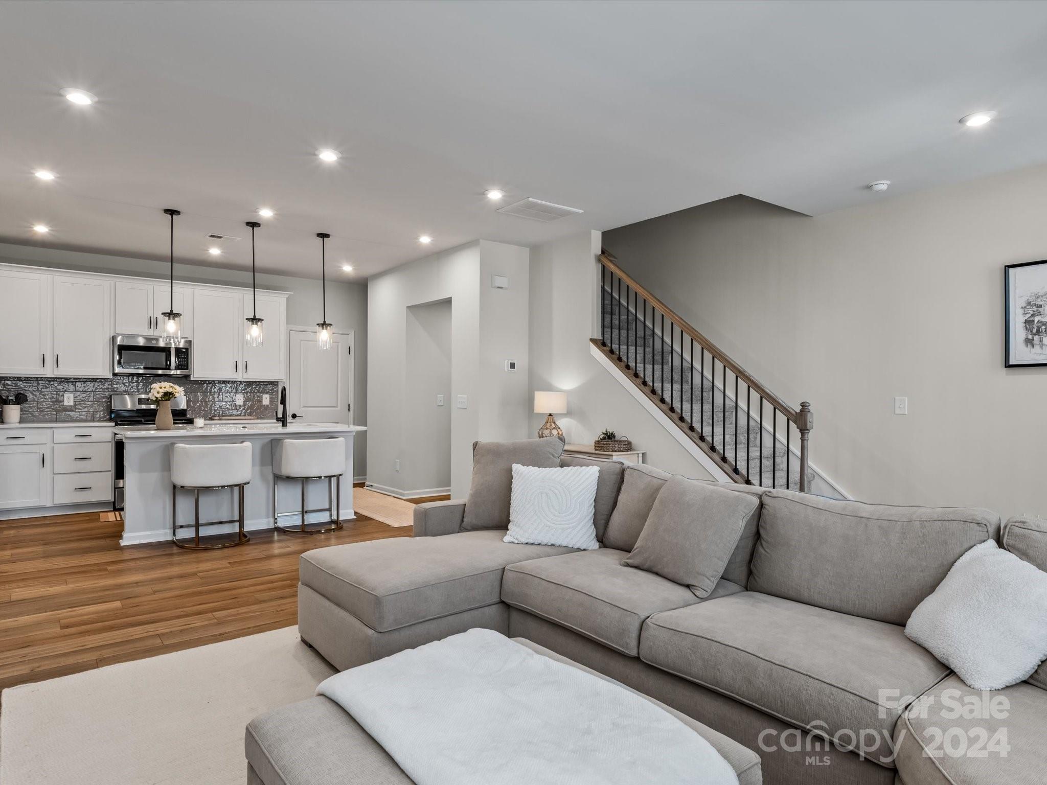 a living room with furniture and kitchen view