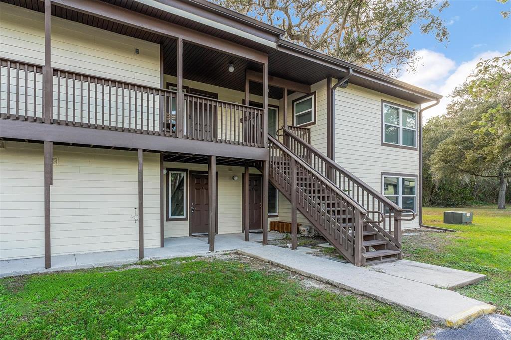 a view of a house with a deck and a yard