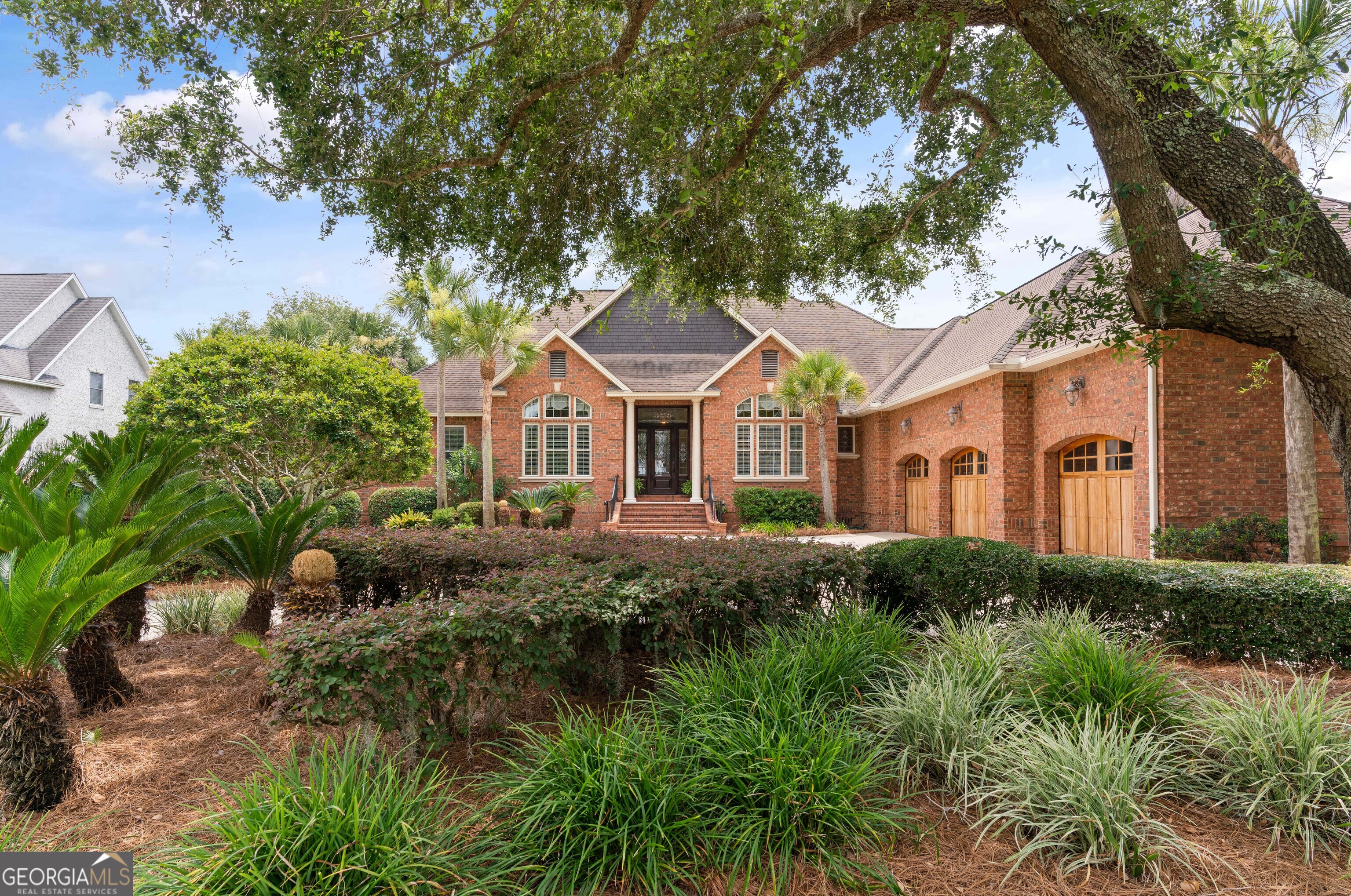 a front view of a house with yard and green space