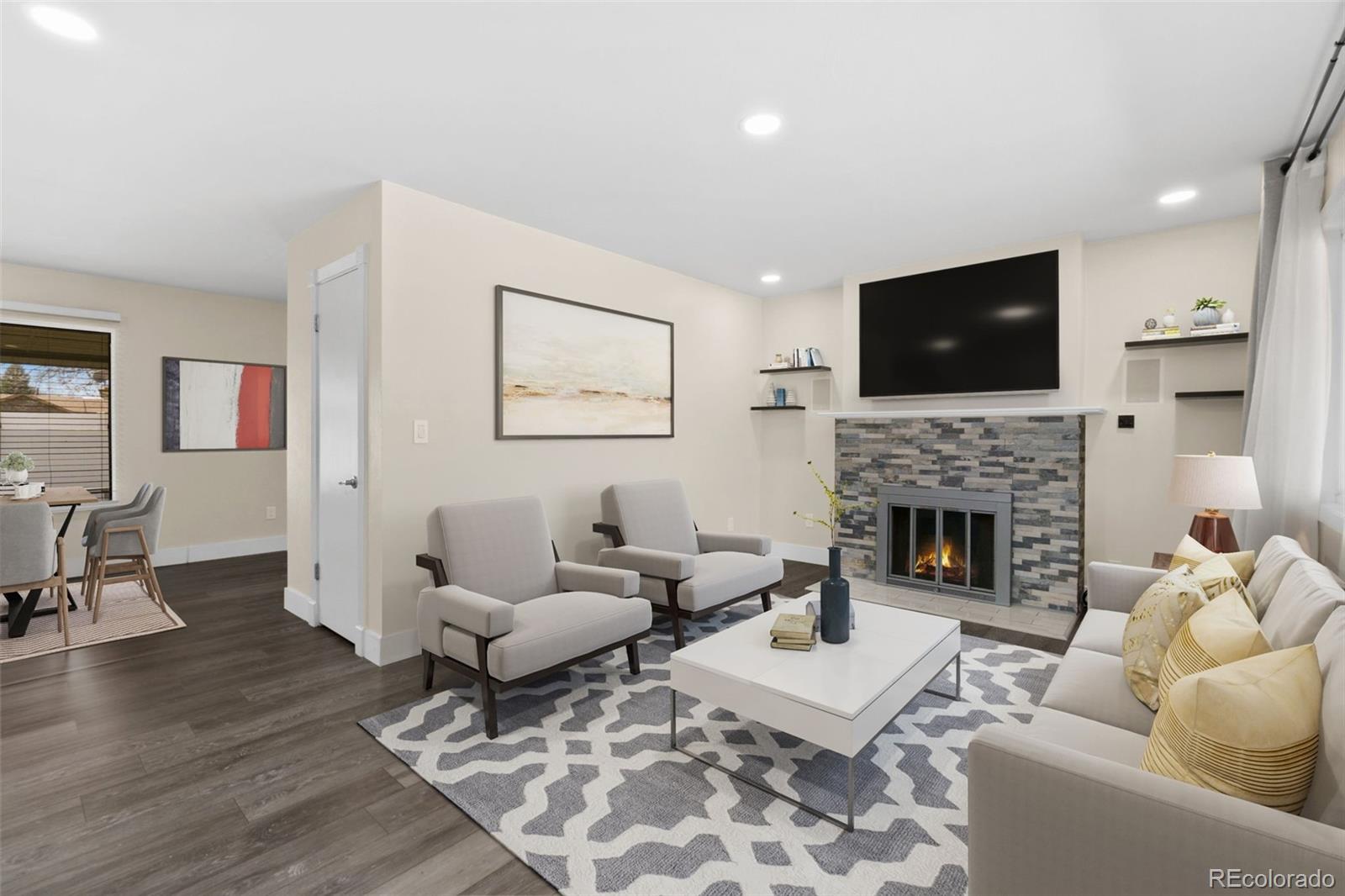 a living room with furniture a flat screen tv and a fireplace