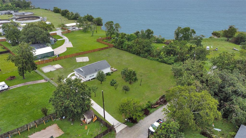 an aerial view of a residential houses with outdoor space and trees all around