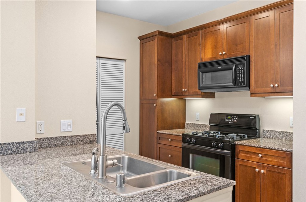 a kitchen with granite countertop a stove and a microwave