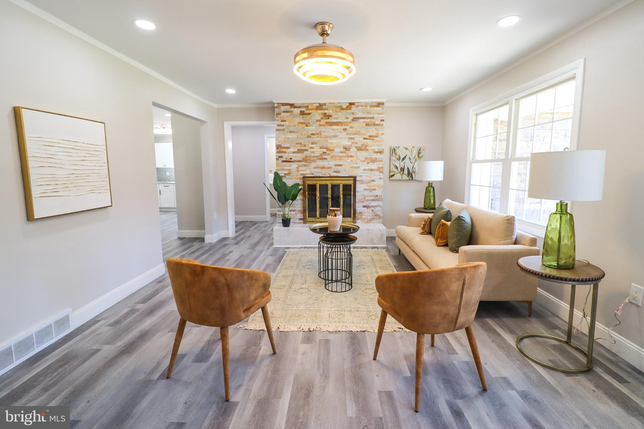 a living room with furniture a lamp wooden floor and a large window