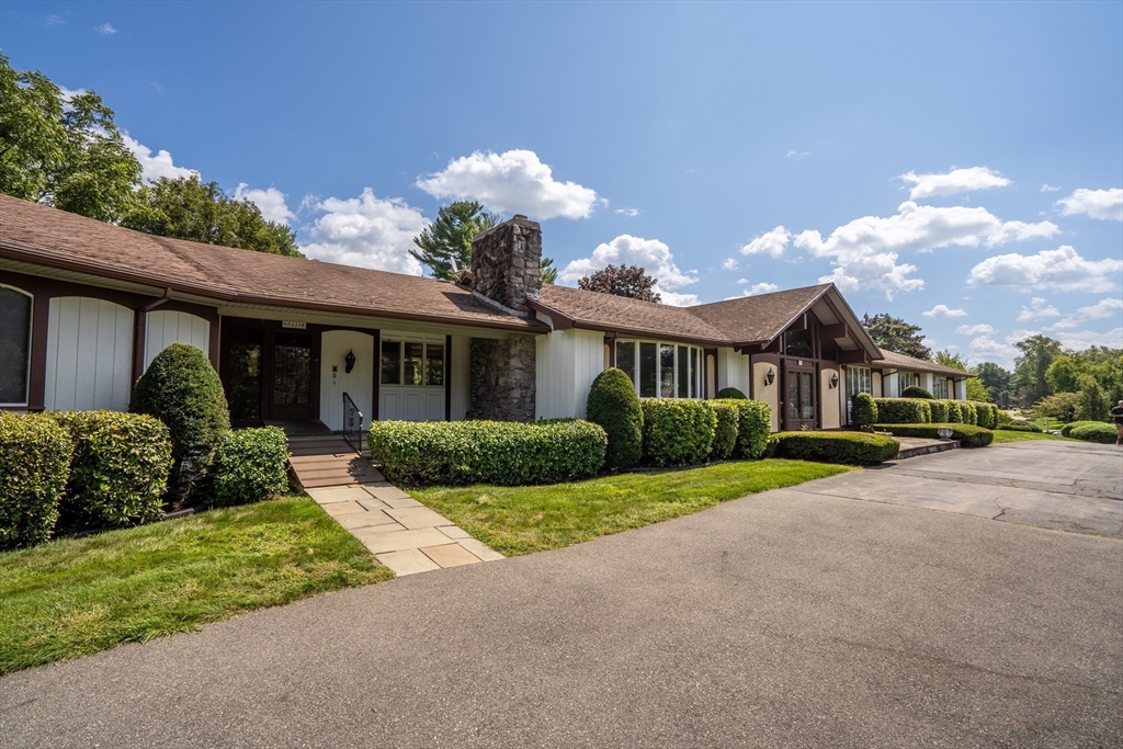 a front view of a house with a yard and potted plants