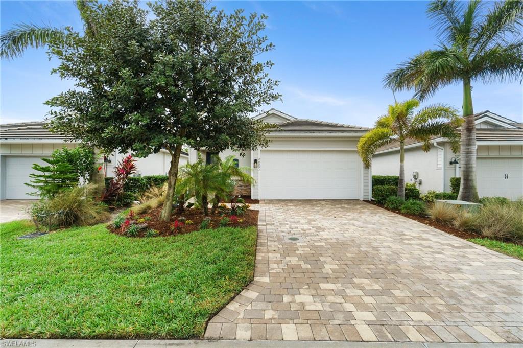 Obstructed view of property with a garage and a front lawn