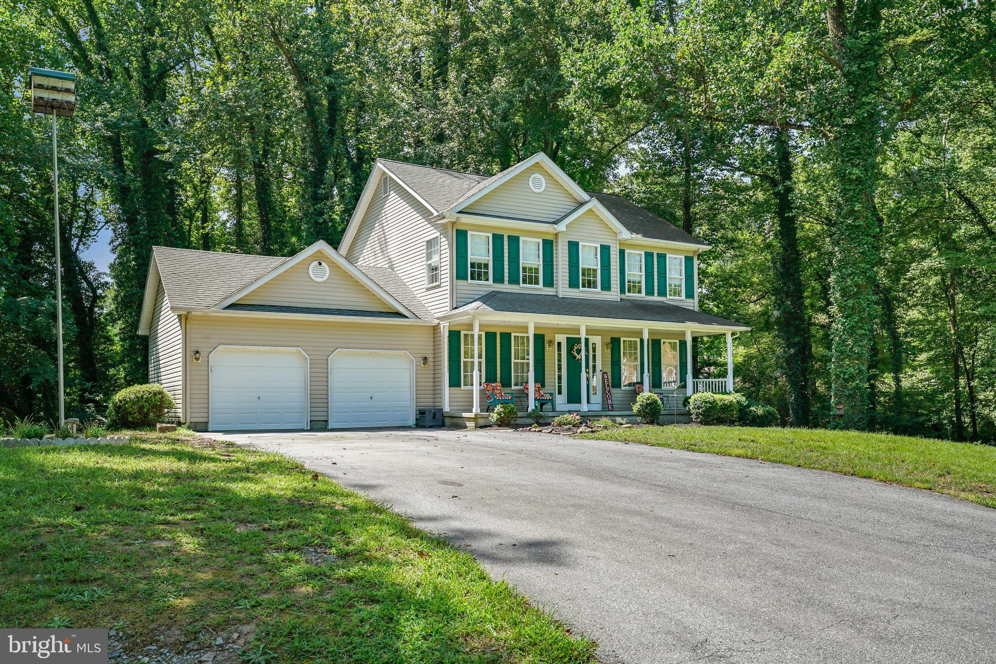 a front view of a house with a yard and trees