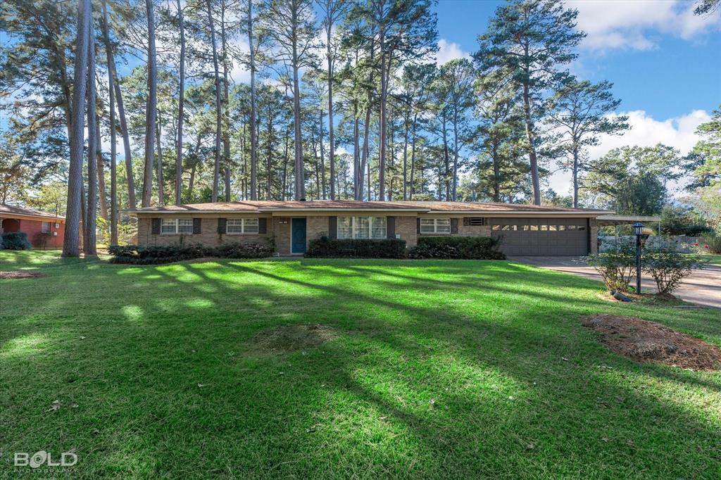 a view of house with a backyard