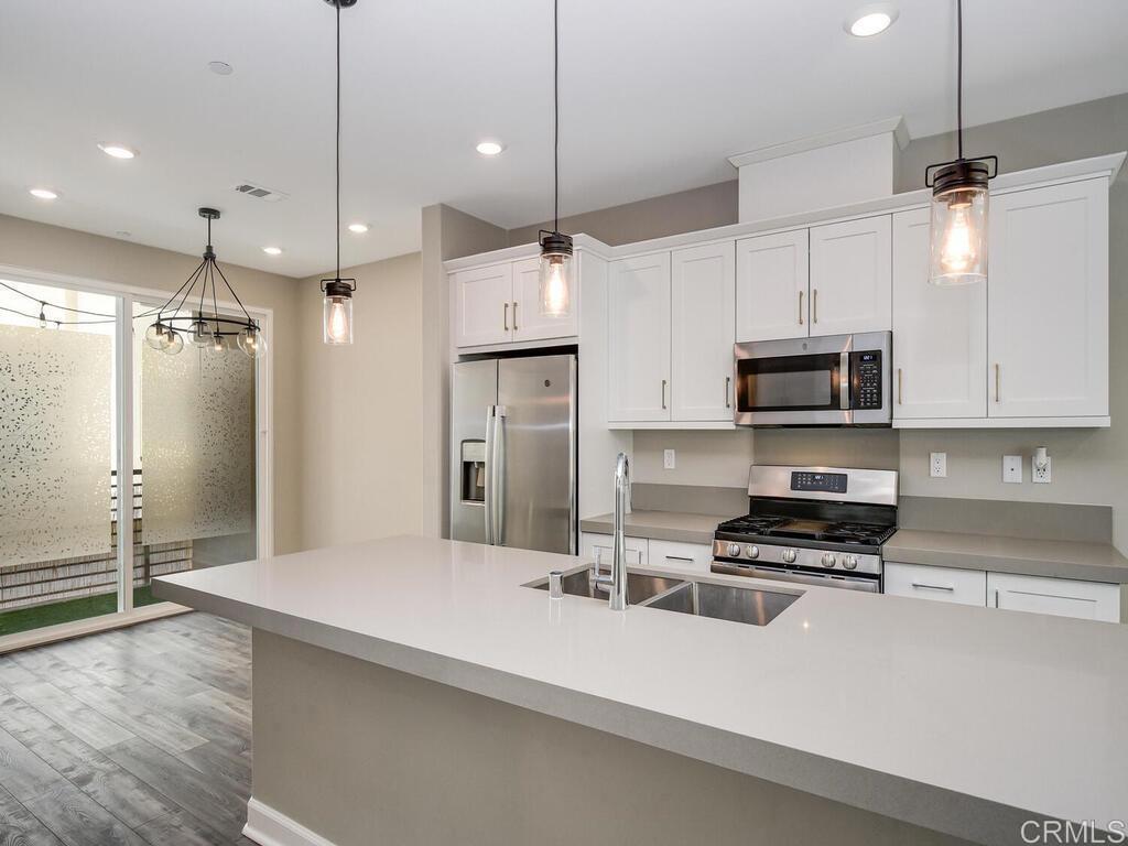 a kitchen with stainless steel appliances a refrigerator sink and microwave