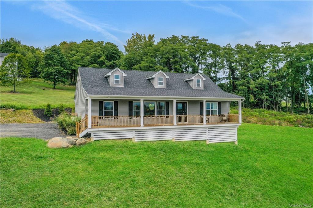 Cape cod house featuring a porch and a front lawn