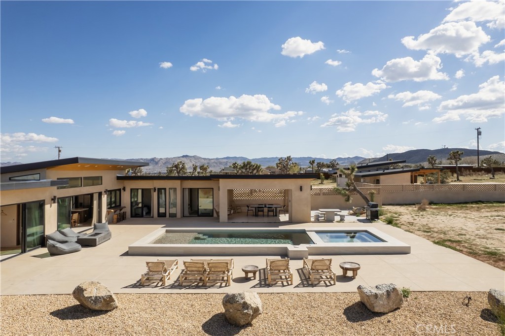 a view of a house with swimming pool and sitting area