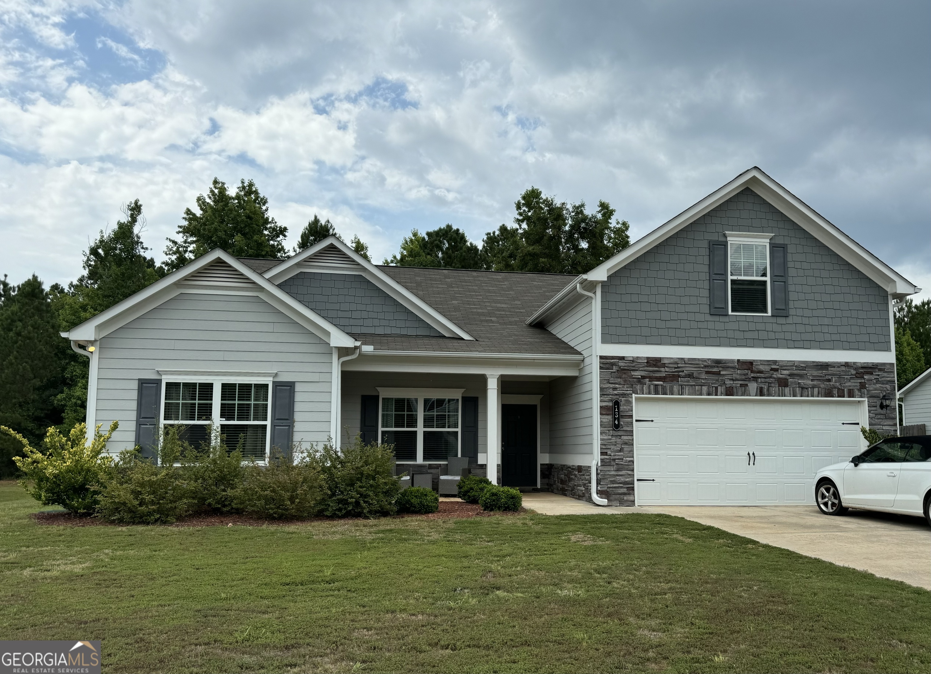 a front view of a house with a garden and yard