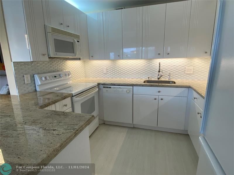 a kitchen with stainless steel appliances granite countertop a sink stove and cabinets