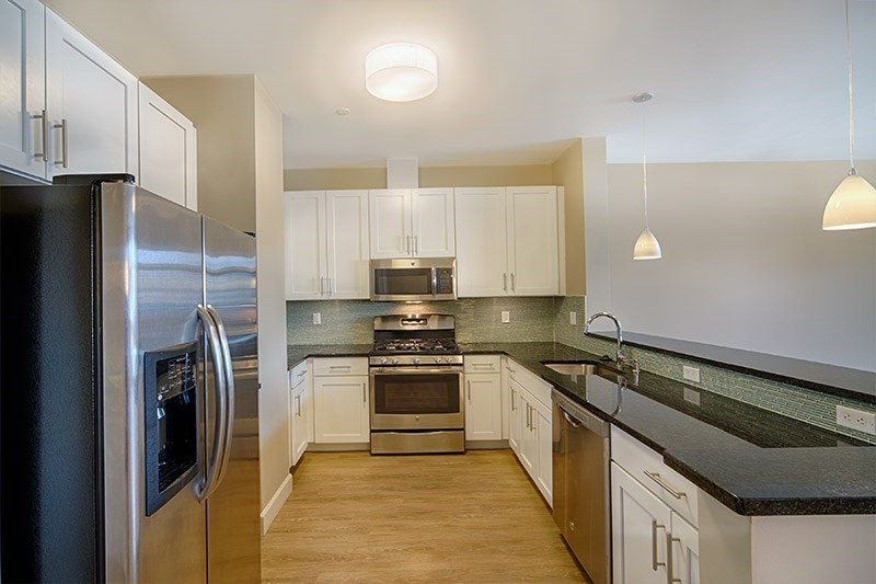 a kitchen with a refrigerator and a stove top oven