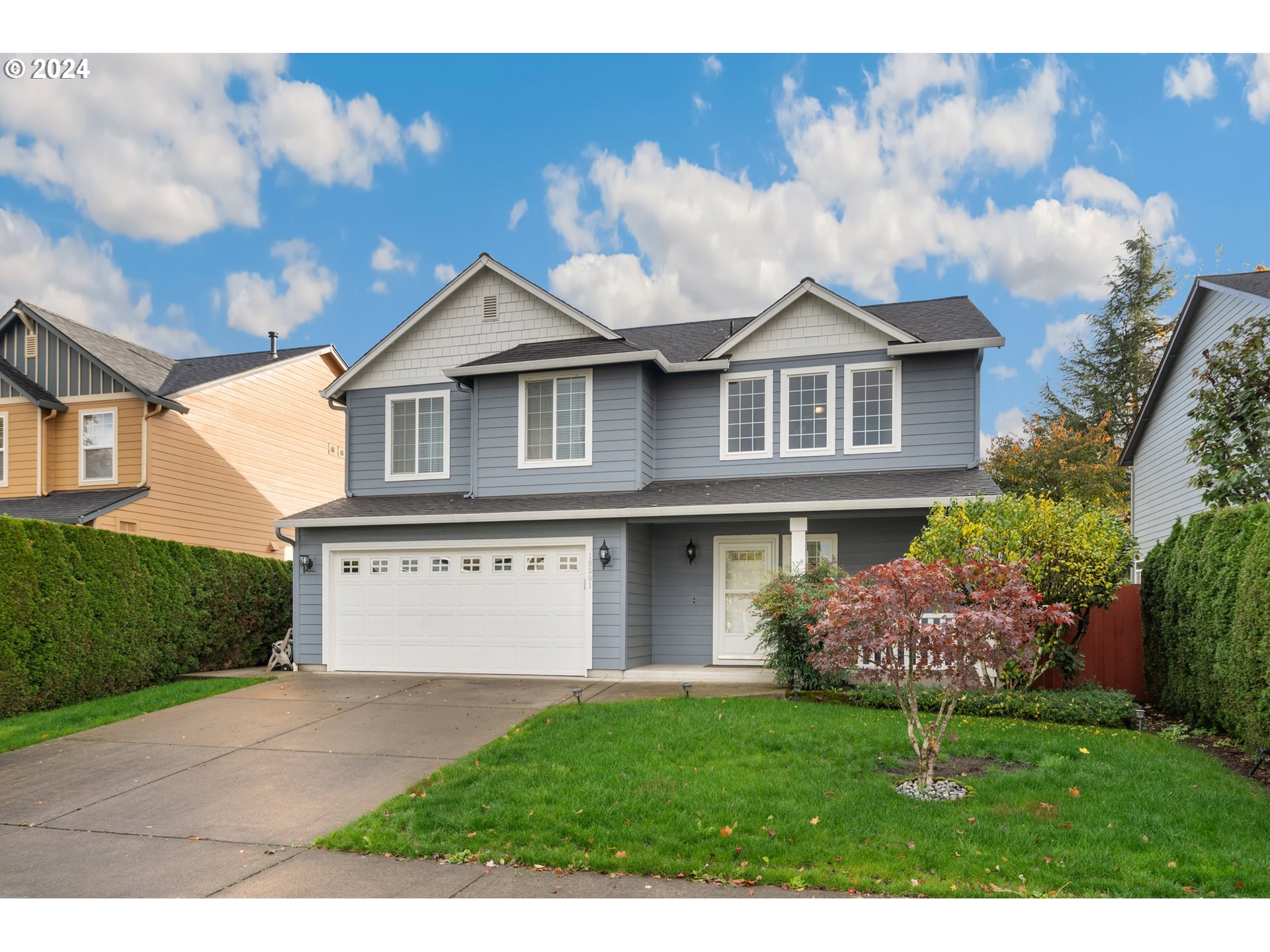 a front view of a house with a yard and garage