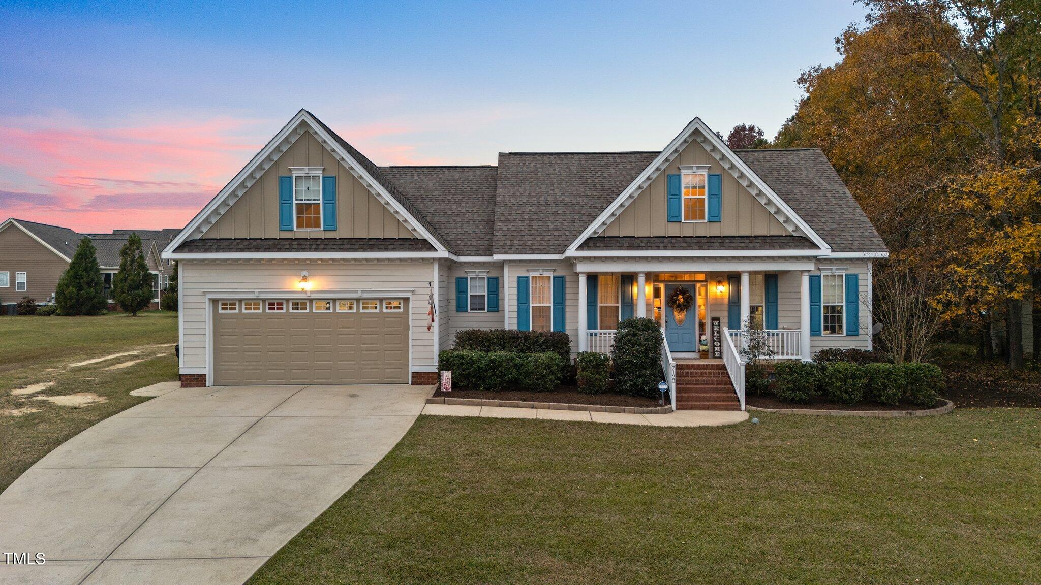 a front view of a house with yard and green space