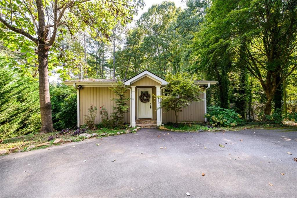 a front view of a house with yard and tree